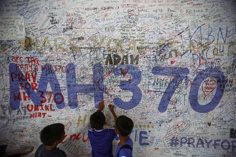 © Reuters. Children write messages of hope for passengers of missing Malaysia Airlines Flight MH370 at Kuala Lumpur International Airport