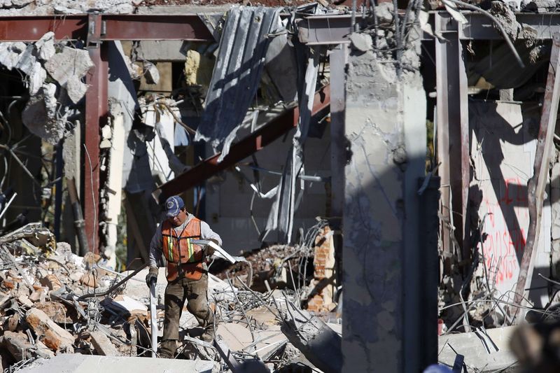 © Reuters. A crew member works to clear debris the day after a deadly gas truck explosion ripped through a maternity hospital in Mexico City