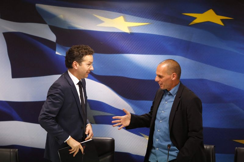 © Reuters. Dijsselbloem, head of the euro zone finance ministers' group, and Greek Finance Minister Yanis Varoufakis shake hands after their common press conference at the ministry in Athens