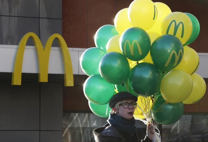 © Reuters. A customer holds balloons outside a McDonald's restaurant on the day of its reopening in central Moscow