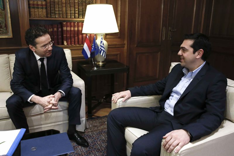 © Reuters. Dijsselbloem, head of the euro zone finance ministers' group, sits with Greece's Prime Minister Tsipras as he is welcomed to his office in Athens