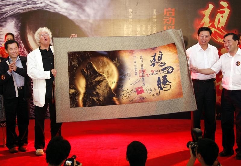 © Reuters. French movie director Annaud makes the sound of a wolf howling during a media conference in Beijing