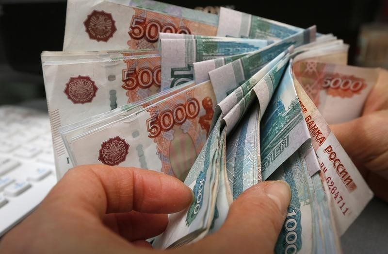 © Reuters. An employee counts Russian rouble banknotes at a small private shop in Krasnoyarsk