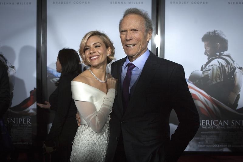 © Reuters. Actress Sienna Miller and director Clint Eastwood arrive for the premiere of the film "American Sniper" in New York