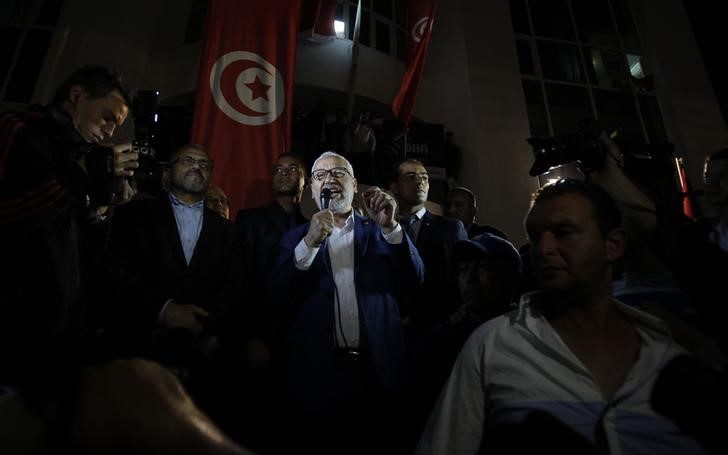 © Reuters. Rached Ghannouchi, leader of the Islamist party Ennahda, gives a speech outside Ennahda's headquarters in Tunis