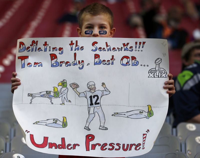 © Reuters. A young fan of New England Patriots quarterback Tom Brady holds up a sign before the start of the NFL Super Bowl XLIX football game against the Seattle Seahawks in Glendale