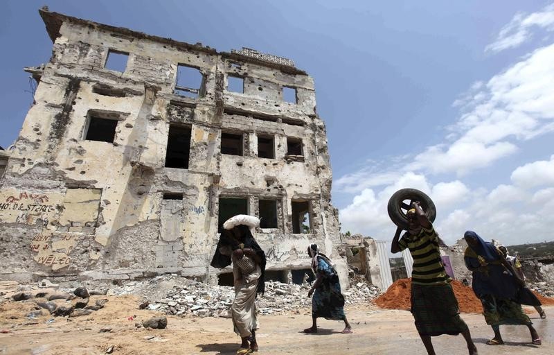 © Reuters. Displaced people walk past a war-devastated village in Bakara district, south of Mogadishu