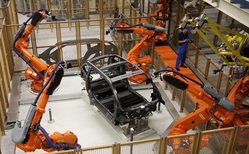 © Reuters. A worker makes technical measurements with robots on the carbon chassis at the serial production BMW i3 electric car in the BMW factory in Leipzig