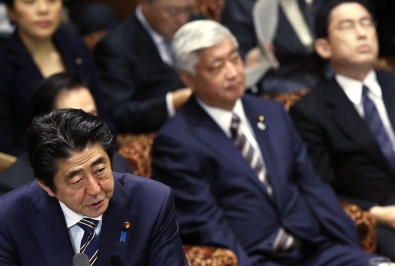 © Reuters. Japan's PM Abe speaks next to Defence Minister Nakatani and Foreign Minister Kishida during an upper house committee session at the parliament in Tokyo