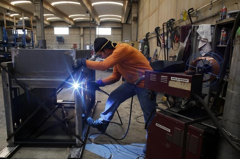 © Reuters. A worker welds a metal furnace in a factory in Gravellona Lomellina