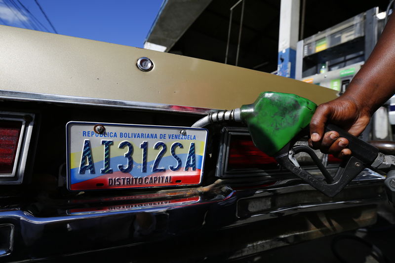 © Reuters. A worker fills up a car with fuel at a gas station in Caracas