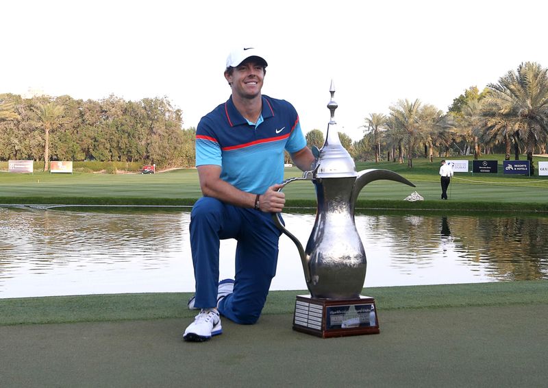 © Reuters. Rory McIlroy of Northern Ireland poses with the winners trophy after the final round of the Dubai Desert Classic