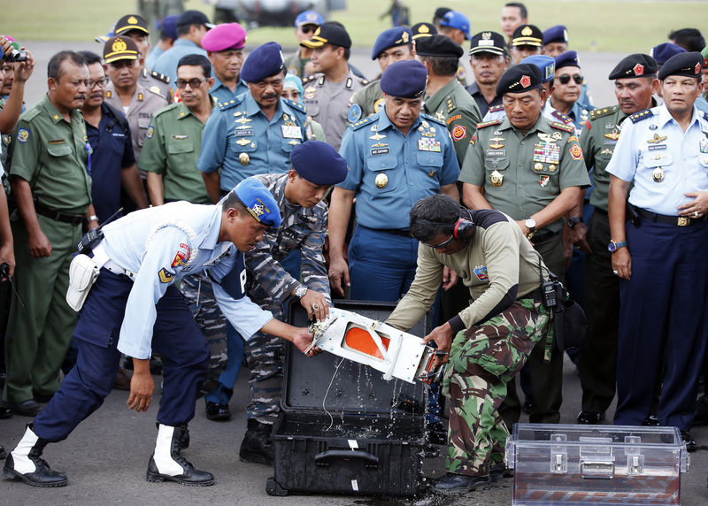 © Reuters. The flight data recorder of AirAsia QZ8501 is transferred to another container at the airbase in Pangkalan Bun