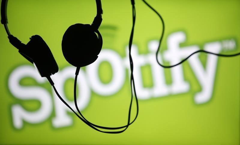 © Reuters. Headsets hang in front of a screen displaying a Spotify logo on it, in Zenica