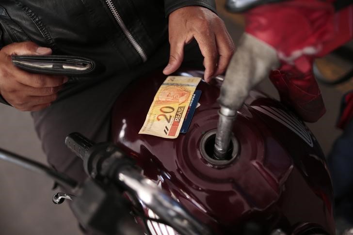 © Reuters. A gas station employee refuels a motorcycle in Brasilia