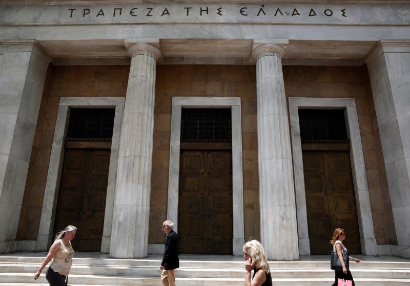 © Reuters. People make their way in front of the Bank of Greece in Athens