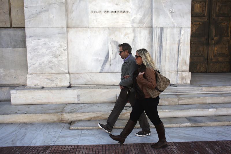 © Reuters. People pass in front of the Bank of Greece in Athens