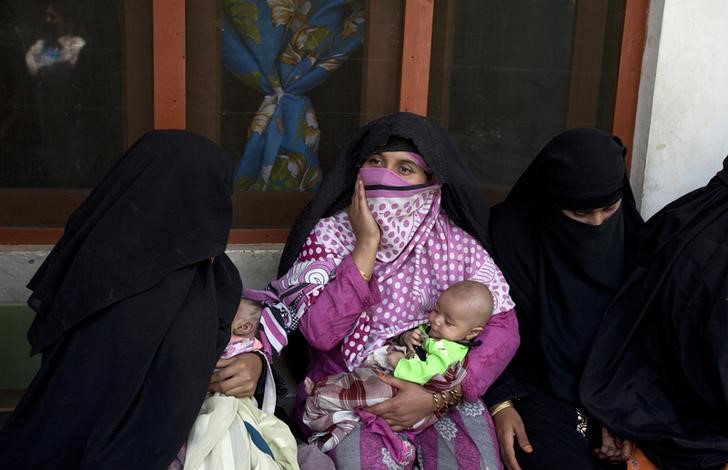 © Reuters. A woman holds a child while waiting their turn to receive fortified food supplements at a centre for malnourished women and children during a visit of Ertharin Cousin, the executive director of the World Food Program (WFP) in Baidara in Swat valley