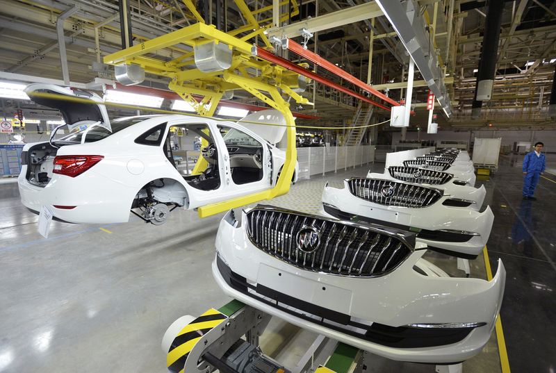 © Reuters. An employee looks on next to an assembly production line of Buick cars at a General Motors factory in Wuhan