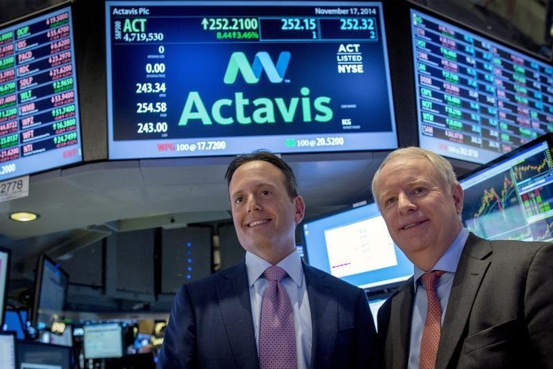 © Reuters. Actavis CEO Brenton Saunders and Allergan CEO David Pyotton pose together on the floor of the New York Stock Exchange