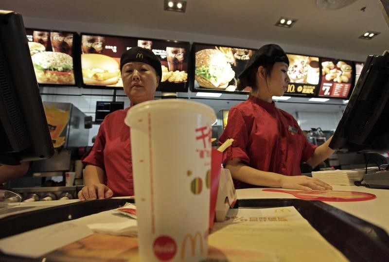 © Reuters. Employees serve food to customers at a McDonald's restaurant at Wangfujing shopping street in Beijing