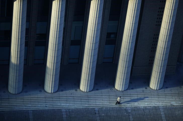 © Reuters. A man walks along an area of the Pudong financial district in Shanghai