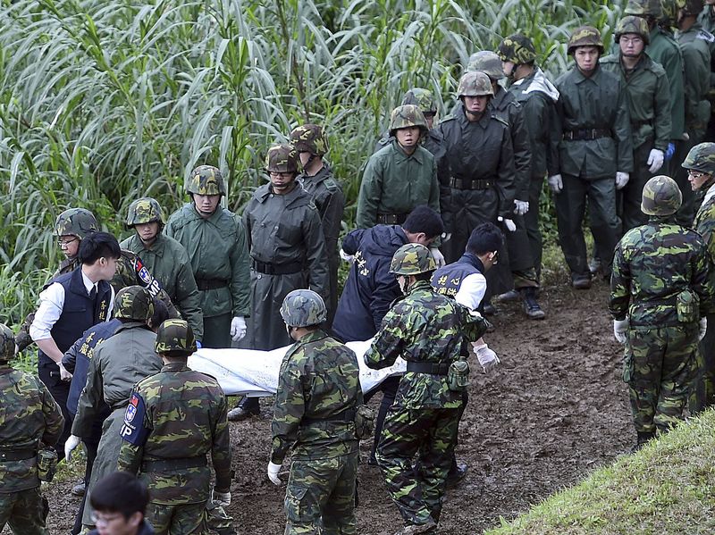 © Reuters. Soldiers carry a body after a TransAsia Airways plane crash landed in a river in New Taipei City