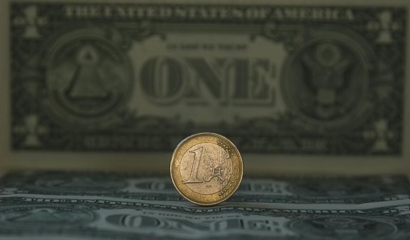 © Reuters. A one Euro coin is placed over one dollar notes in this illustrative photograph taken in Madrid