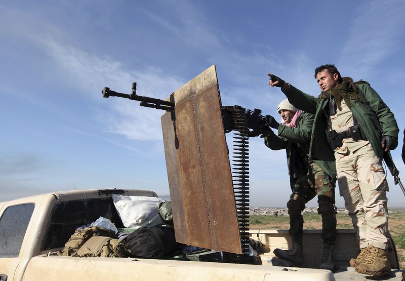 © Reuters. Kurdish Peshmerga fighters keep watch during the battle with Islamic State militants on the outskirts of Mosul