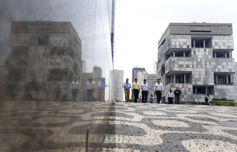 © Reuters. People walk next to the Petrobras headquarters in Rio de Janeiro