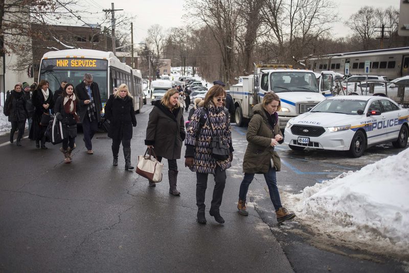 © Reuters. Commuters affected by Tuesday night's train crash exit a bus, provided by the Metropolitan Transportation Authority (MTA), as they arrive to get a train from the North White Plains station in White Plains, New York