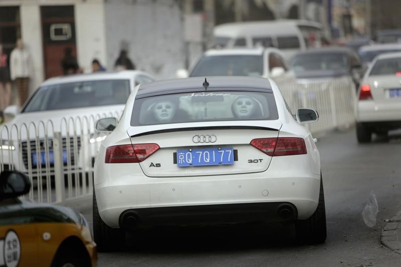 © Reuters. Masks are seen behind the back seats of an Audi A5 as it travels on a road in Beijing