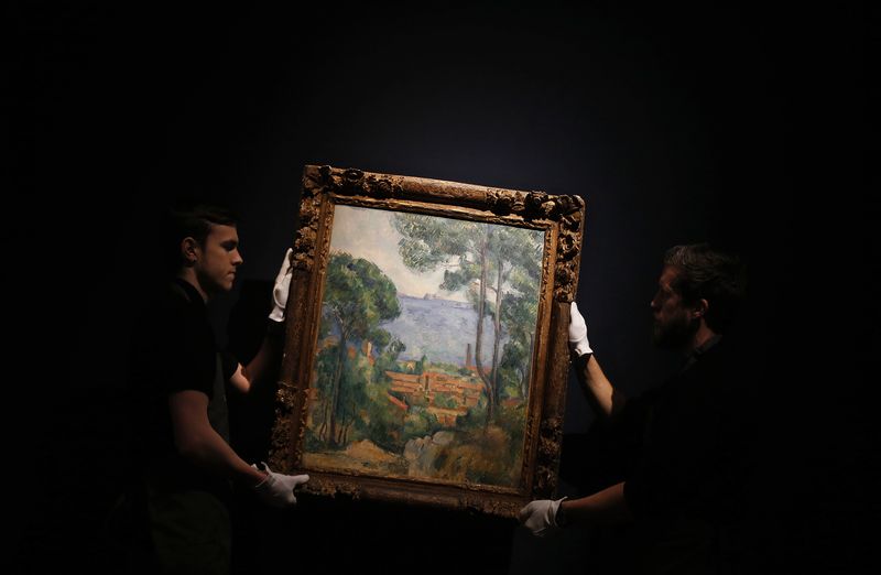 © Reuters. Art handlers pose with "Vue sur l'Estaque et le Chateau d'If" by Paul Cezanne at Christie's auction house in London