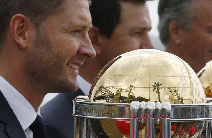 © Reuters. Sydney Harbour Bridge is reflected in a trophy as Australian cricket team captain Michael Clarke gathers with former captains during an event marking the 100-day countdown to the 2015 Cricket World Cup in Sydney