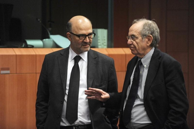 © Reuters. European Commissioner for economics, taxation and customs Pierre Moscovici chats with Italian Finance Minister Pier Carlo Padoan during an Euro zone finance ministers meeting in Brussels