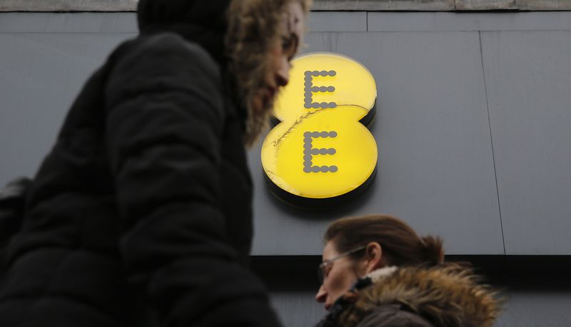 © Reuters. Pedestrians walk past an EE shop in London