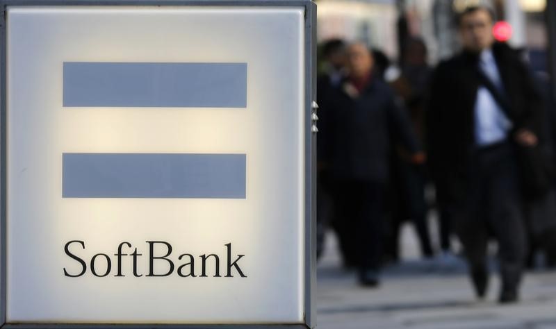 © Reuters. People walk behind the logo of SoftBank Corp in Tokyo