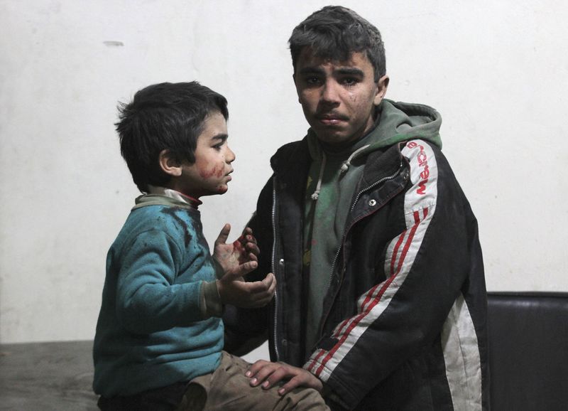 © Reuters. A civilian waits with his injured brother in a field hospital after what activists said were at least 20 air strikes by forces loyal to Syria's President Bashar al-Assad in the Douma neighbourhood of Damascus