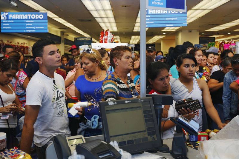 © Reuters. Pessoas esperam a vez para pagar dentro de uma farmácia da Farmatodo em Caracas