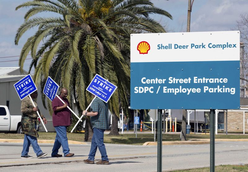 © Reuters. Workers from the USW union walk a picket line outside the Shell Oil Deer Park Refinery in Deer Park, Texas