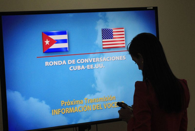 © Reuters. A journalist stands near a screen announcing a round of negotiations between Cuba and the U.S. in Havana