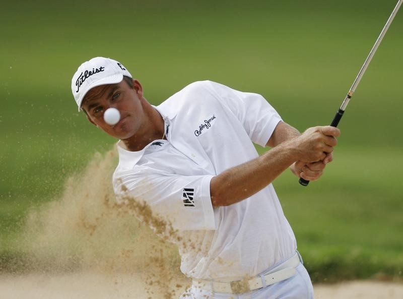 © Reuters. Thompson of the U.S. watches his ball as he hits out of the bunker by the 18th green during the first round of the Sony Open in Honolulu