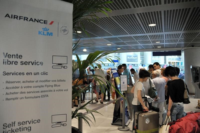 © Reuters. Passengers form a queue at an Air France ticketing counter at the  Nice Cote d'Azur international airport in Nice