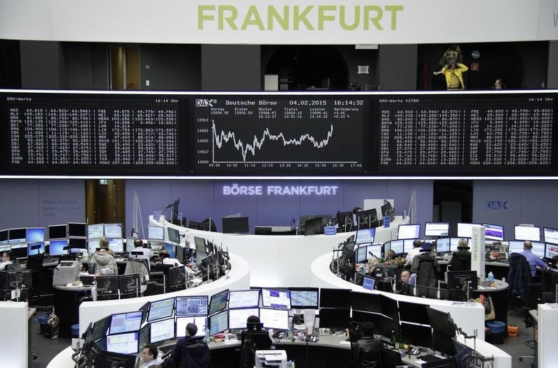 © Reuters. Traders are pictured at their desks in front of the DAX board at the Frankfurt stock exchange