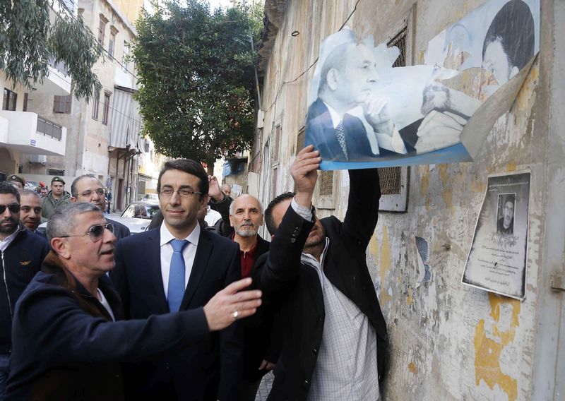 © Reuters. Beirut governor Ziad Chebib supervises the removal of political posters and party banners along a street in Beirut