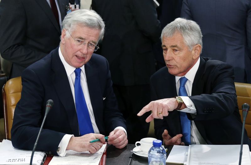 © Reuters. Britain's Defence Secretary Fallon listens to U.S. Secretary of Defense Hagel during a NATO defence ministers meeting in Brussels