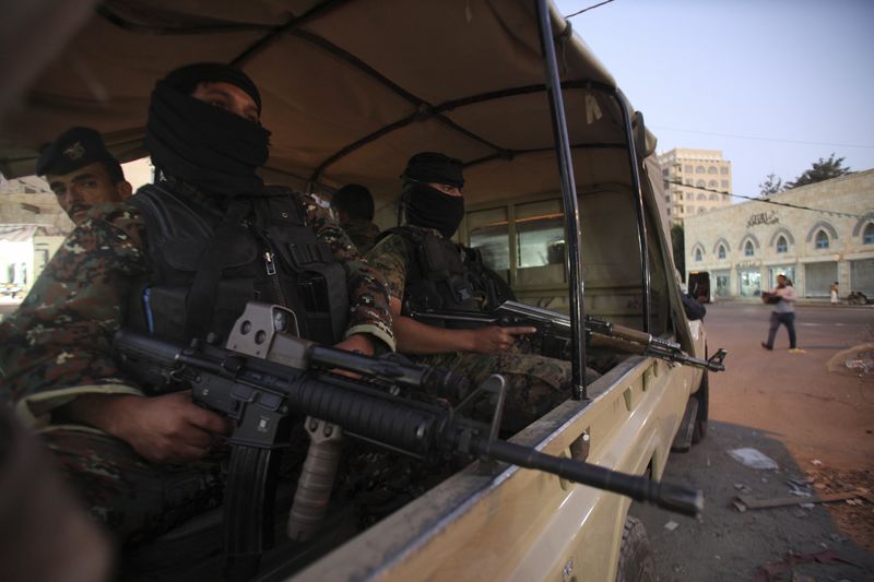 © Reuters. Houthi fighters in police uniform guard outside the president palace in Sanaa