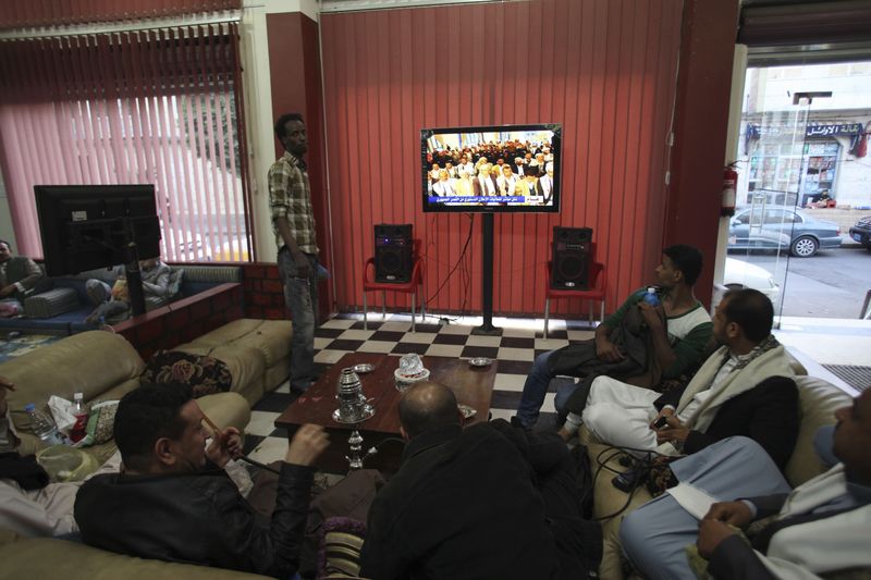 © Reuters. Pessoas assistem a pronunciamento do movimento Houthi na TV em Sanaa