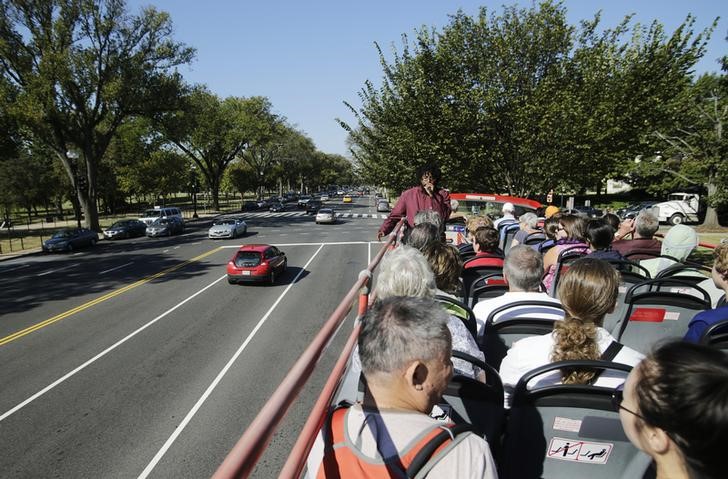 © Reuters. Tourists pass by light traffic while driving on Constitution Avenue in Washington atop a tour bus