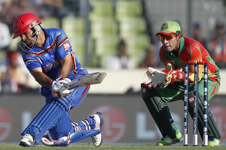 © Reuters. Afghanistan's captain Nabi plays a ball as Bangladesh's captain and wicketkeeper Rahim watches during ICC Twenty20 World Cup match in Dhaka